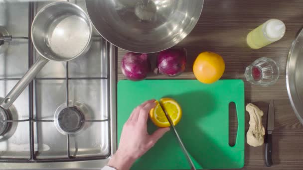 Шеф-повар режет апельсин на доске — стоковое видео
