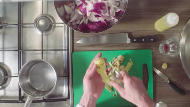 Шеф-повар чистит и режет корень имбиря на доске — стоковое видео