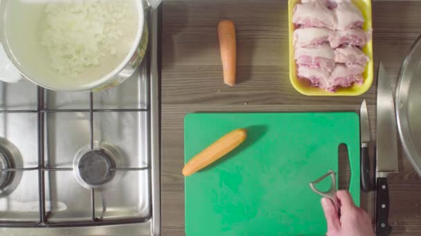 Пилинг шеф-повара и резка моркови на доске — стоковое видео