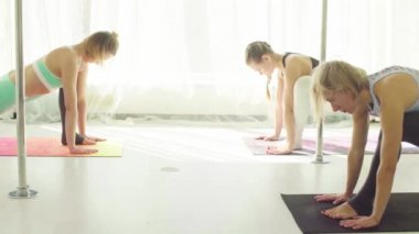 İki kadın Studio yoga egzersizleri yapıyor.