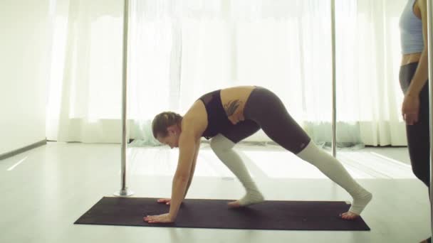 Två unga kvinnor utövar akrobatisk yoga. — Stockvideo