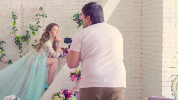 Pretty model in peignoir posing against white wall — Stock Video