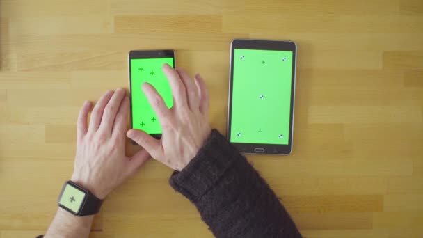 テーブルの上の緑の画面で 3 つのデバイス — ストック動画