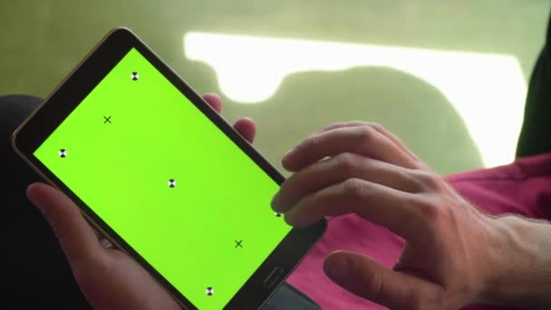 Male hand scrolling a tablet with green screen — Stock Video