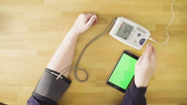 Senior woman measuring her own blood pressure — Stock Video