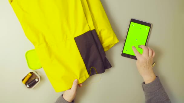 Green screen. Hands of old woman sewing pants — Stock Video