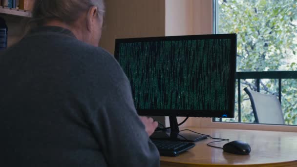 Старуха печатает на зеленом экране компьютера — стоковое видео