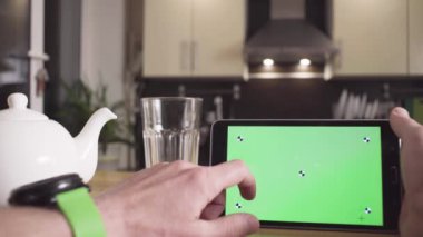 Erkek el bir tablet yeşil ekran ile kaydırma