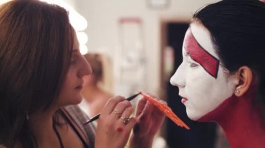 Çizgi çizim modelleri yüzünde makyaj sanatçısı