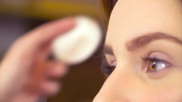 O artista de maquiagem corrigindo a forma da sobrancelha — Vídeo de Stock