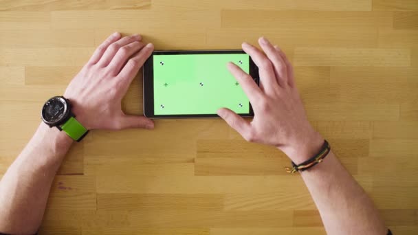 Main masculine faisant défiler une tablette avec écran vert 