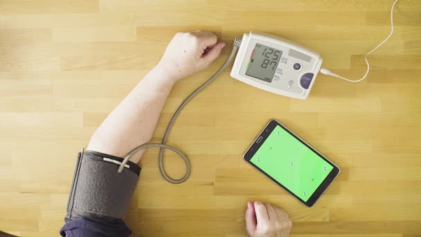 Старша жінка вимірює власний кров'яний тиск — стокове відео