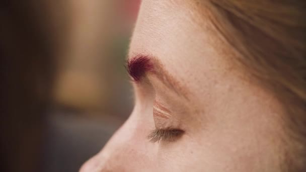 El artista de maquillaje para colorear ceja roja de un modelo — Vídeos de Stock