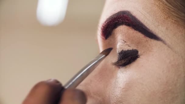 El maquillador aplicando sombra de ojos en los ojos — Vídeo de stock