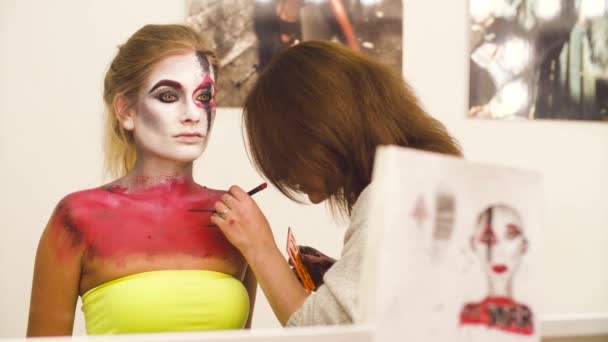 Maquillaje artista dibujo en la cara modelos — Vídeos de Stock