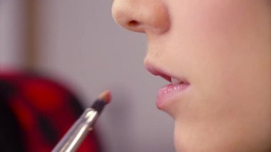 Dudak parlatıcısı uygulayarak makyaj sanatçısı