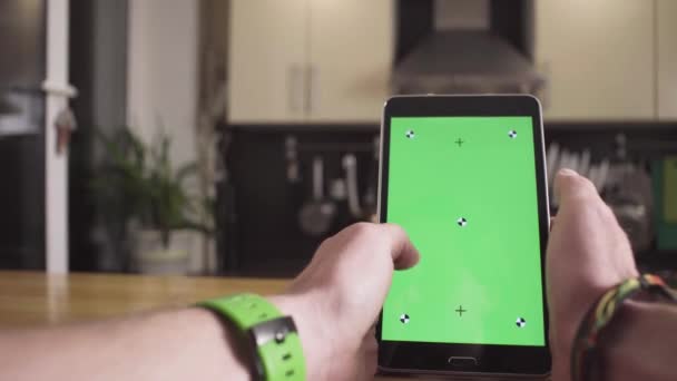 Мужская рука прокручивает планшет с зеленым экраном — стоковое видео