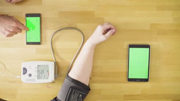 Young man measuring blood pressure of senior woman — Stock Video