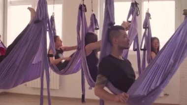 Bir grup insan hava yoga asanas spor salonunda yapıyor