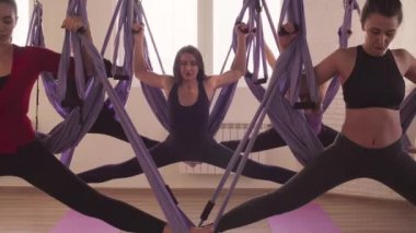 Bir grup insan hava yoga asanas spor salonunda yapıyor