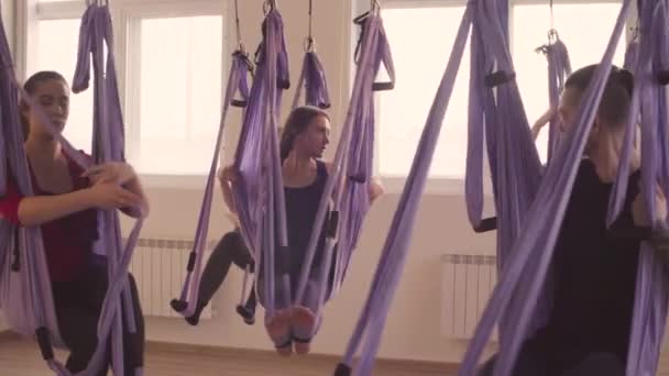 Bir grup insan hava yoga asanas spor salonunda yapıyor — Stok video