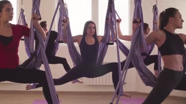 Groupe de personnes faisant des asanas de yoga aérien dans la salle de gym — Video