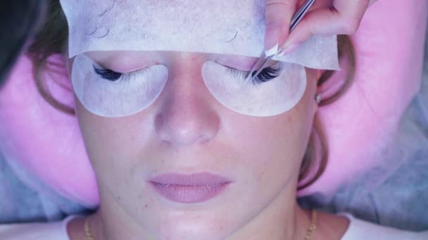 Kvinna ansikte. Ögonfrans förlängning förfarande i salong — Stockvideo