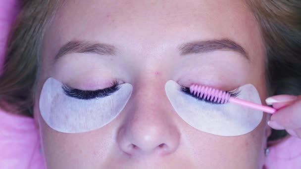 Un visage de femme. Cosmetologue peignage des cils — Video