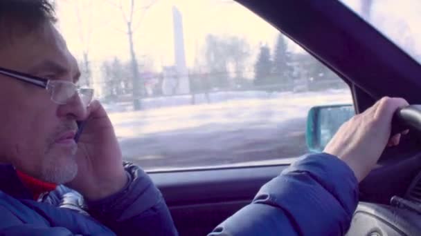 Starší muž řídil auto a mluví o mobilní telefon — Stock video