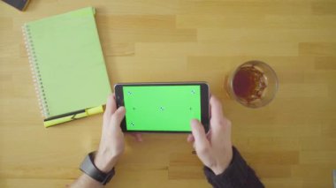 Adam yeşil ekranlı tablet bir oyun oynuyor