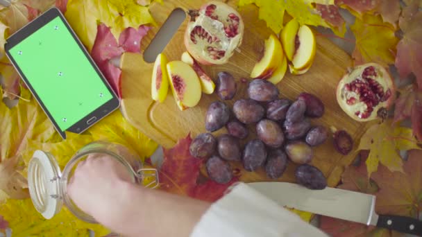 Autumn naturemorte. Chef putting plums in a jar — Stock Video