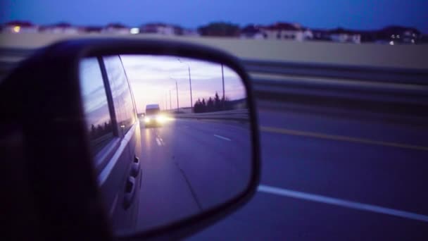 Rear view mirror in a moving car at evening. — Stock Video