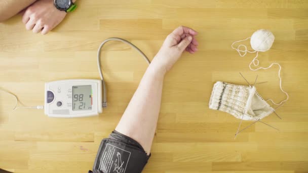 Hombre joven midiendo la presión arterial de la mujer mayor — Vídeo de stock