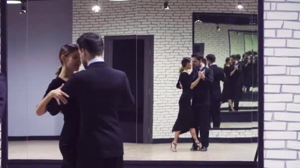 Bailarines profesionales bailando tango en salón . — Vídeo de stock