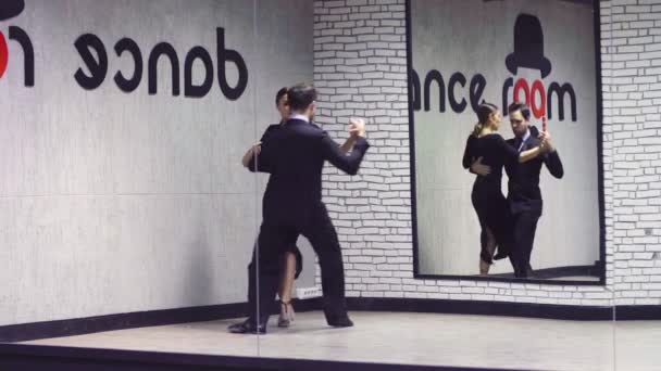 Bailarines profesionales bailando tango en salón . — Vídeo de stock