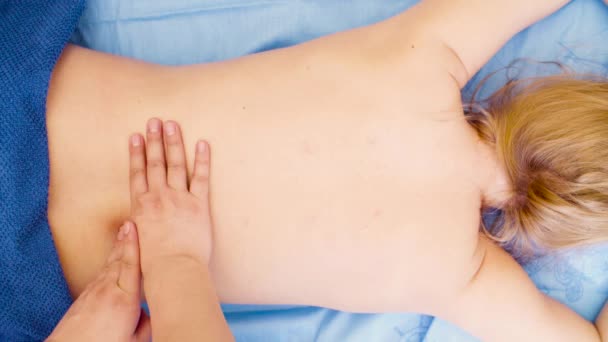 Руки терапевта, делающего массаж спины — стоковое видео
