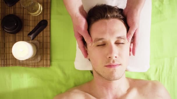 Manos de terapeuta haciendo masaje de cara masculina — Vídeo de stock