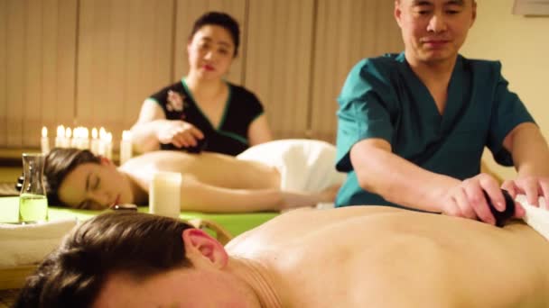 Два китайских терапевта делают вакуумный массаж — стоковое видео