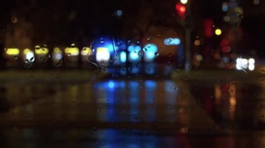 Pencere camına yağmur damlası. Bulanık şehir trafik ışıkları. Şehir geçmişi. Canlandırma artı video