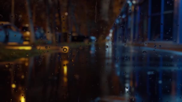 Vitre de fenêtre en temps de pluie. feux de circulation nocturnes Bokeh . — Video