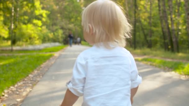 Bébé mignon marchant le long de la route dans le parc 