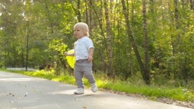 Küçük çocuk sarı balonla oynuyor.