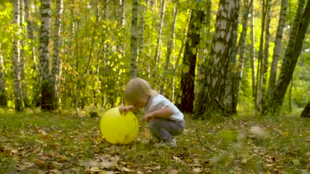Маленька смішна дитина з жовтою кулею — стокове відео
