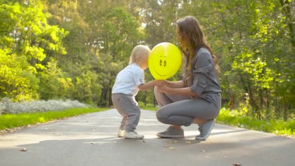 Ung mor och rolig bebis i parken — Stockvideo