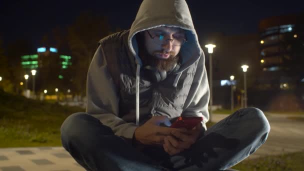 Jovem com telefone inteligente no parque — Vídeo de Stock