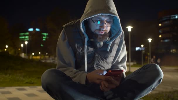 Anak muda dengan ponsel pintar di taman — Stok Video