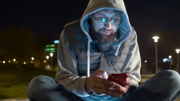 Jovem com telefone inteligente no parque — Vídeo de Stock