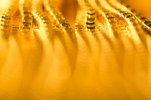 Abstraktní zlaté pozadí, rozmazané De zaměřil Zlatý řetěz, kovové žlutá — Stock fotografie