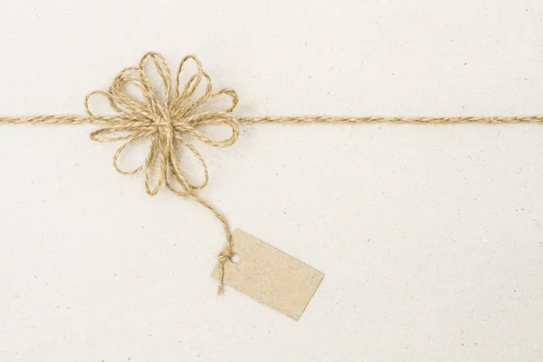 Štítek s papíru a lano luk dekorace, balicí papír motouzy pásu karet — Stock fotografie