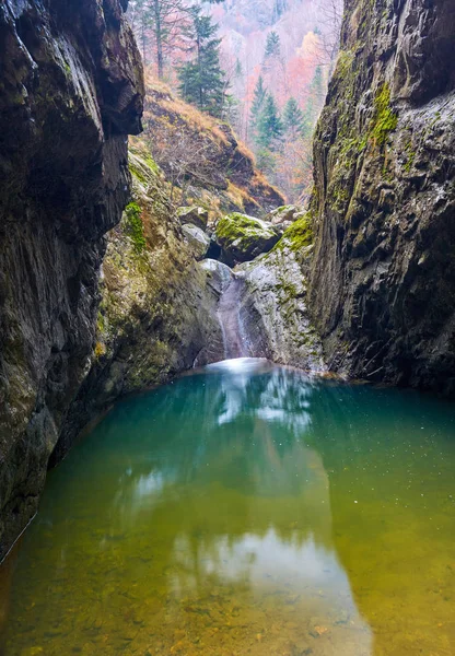 Desfiladeiro e uma cachoeira em montanhas rochosas — Fotografia de Stock